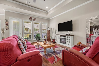 Living area featuring wood finished floors, crown