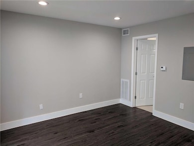 Spare room with electric panel, visible vents, ba