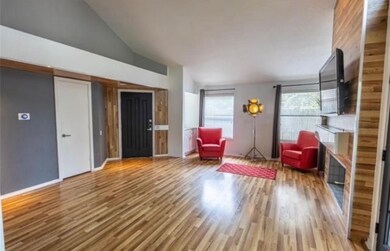Sitting room featuring wood finished floors and high vaulted ceiling
