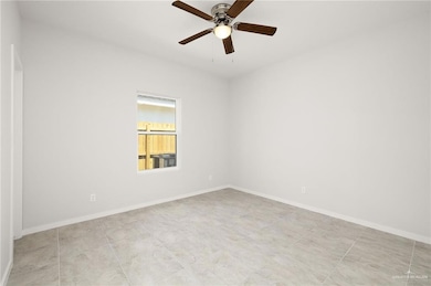 Spare room with baseboards and a ceiling fan