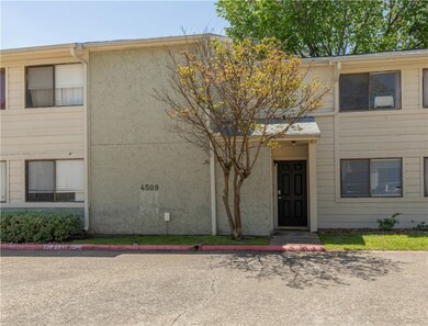 View of property with uncovered parking and stucco