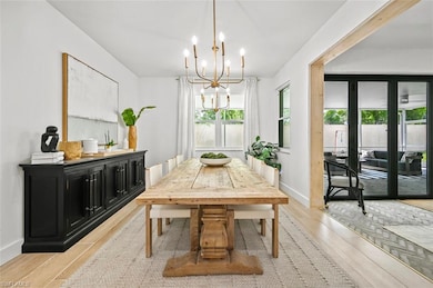 Dining room featuring a chandelier, light wood finished floors, and baseboards