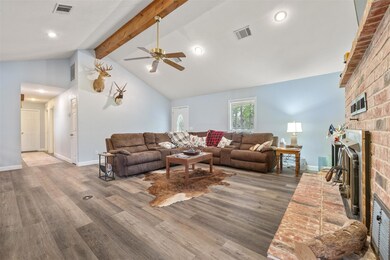 Living area with a fireplace, a ceiling fan, wood