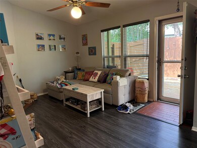 Living room featuring a ceiling fan and wood fini