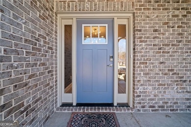 View of exterior entry featuring brick siding