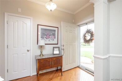 Foyer with ornamental molding and light hardwood f
