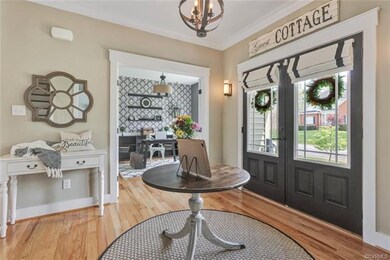 Foyer with oak hardwood floors, Crown moulding, Craftsman trim, custom wall color and lighting