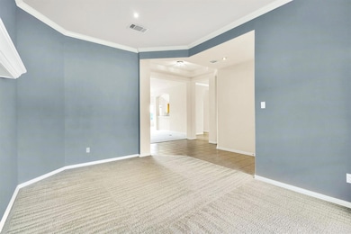 Carpeted empty room featuring arched walkways, or