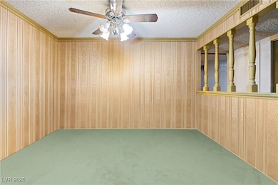 Spare room with carpet floors, a textured ceiling, crown molding, and a ceiling fan