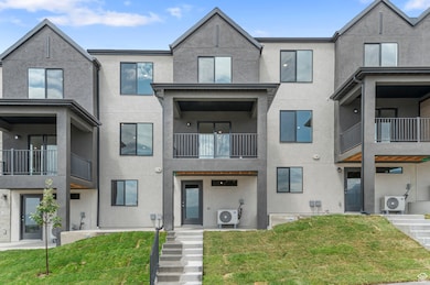 Modern home featuring stucco siding, a patio area, a front lawn, and a balcony