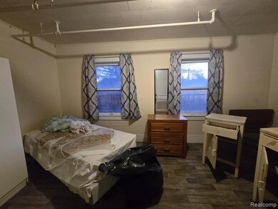 Bedroom featuring dark wood-style flooring and baseboards