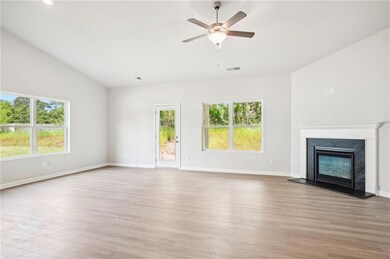 Unfurnished living room featuring light wood-style flooring, a high end fireplace, ceiling fan, and vaulted ceiling