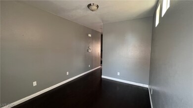 Empty room featuring baseboards and dark wood-type