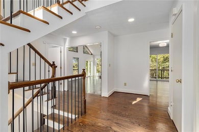 Hall with dark wood-type flooring, a textured ceiling, stairway, and recessed lighting