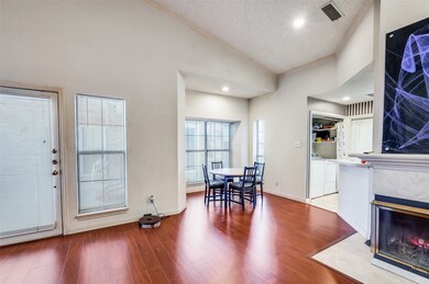 Entryway wood finished floors, dining area, a fireplace, and crown molding
