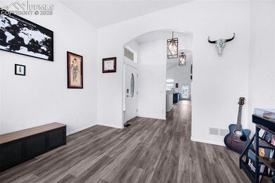 Corridor with arched walkways, wood finished floors, and baseboards
