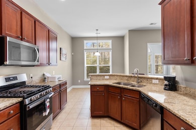 Kitchen featuring light stone counters, light tile