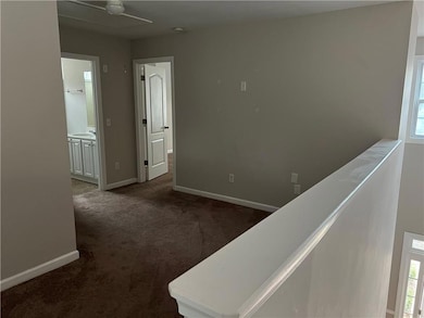 Hallway with dark carpet and sink