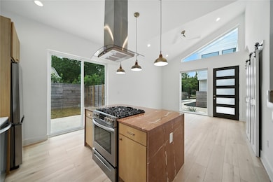 Kitchen with pendant lighting, stainless steel appliances, recessed lighting, a kitchen island, and island range hood