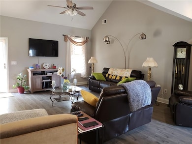 Living room featuring ceiling fan, lofted ceiling,