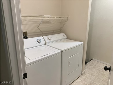 Laundry room with washer and clothes dryer and lig