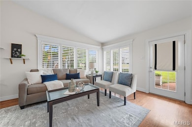 Living area with lofted ceiling and wood finished floors