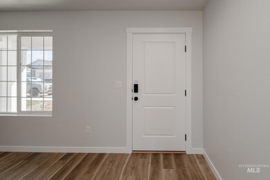 Foyer with baseboards and wood finished floors