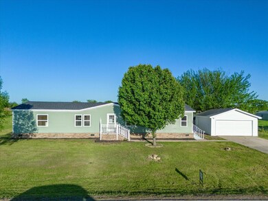 Ranch-style house featuring a front lawn and a garage