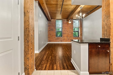 Bar featuring brick wall, wood ceiling, baseboards