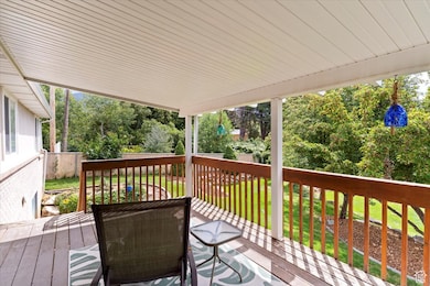 Wooden deck featuring a lawn and view of scattered trees