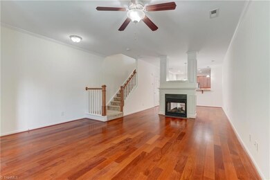 Great room features a double sided gas log fireplace with beautiful surround. Stairs leading to bedrooms above.