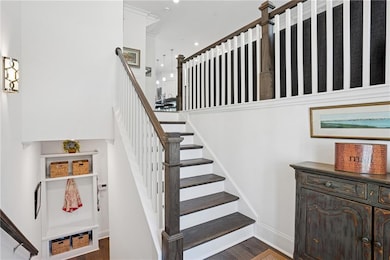 Staircase with baseboards, wood finished floors, a