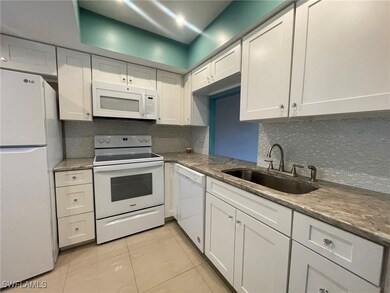 Kitchen featuring white cabinets, sink, white appliances, and tasteful backsplash