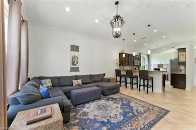 Living area featuring light tile patterned flooring, ornamental molding, and recessed lighting