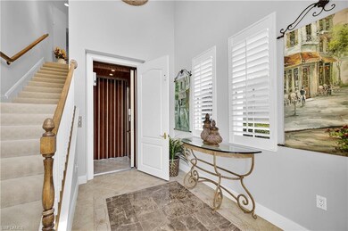 Foyer with stairway, light tile patterned floors, a high ceiling, and elevator