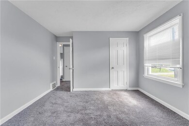 Unfurnished bedroom with light carpet and a closet