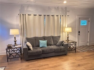 Living room with light hardwood / wood-style floors and crown molding