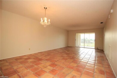 Spare room featuring a chandelier, light tile patterned flooring, and a textured ceiling