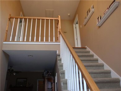 Stairway in foyer leads upstairs and has a small balcony overlooking foyer