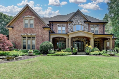 View of front of house featuring brick siding, a front yard, and french doors
