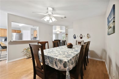 Dining area with a ceiling fan, baseboards, and li
