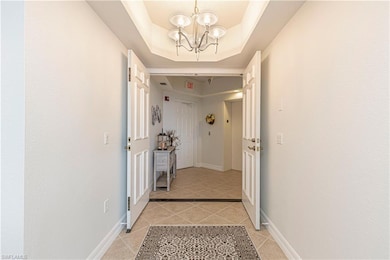 Hallway featuring light tile patterned floors, a c