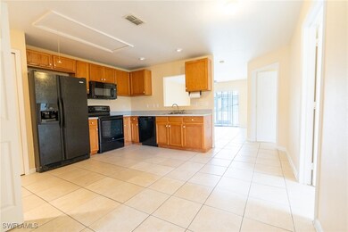 Kitchen featuring black appliances, light tile pat