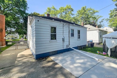Rear view of property featuring a chimney, a patio area, and a gate