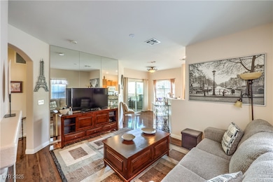 Living area with arched walkways, wood finished fl