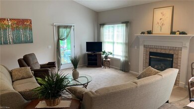 Carpeted living room featuring a fireplace and vaulted ceiling