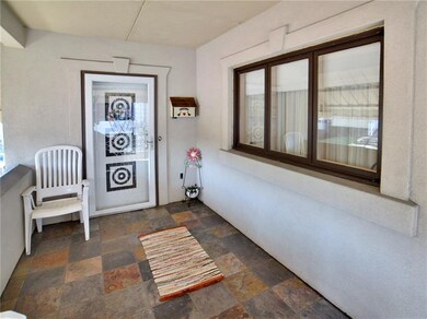 Covered front porch with slate flooring and metal 