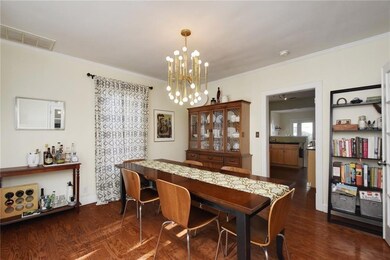 Dining room featuring a chandelier, ornamental molding, and dark wood finished floors