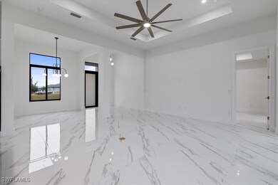 Unfurnished room with a ceiling fan, a raised ceil