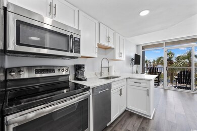 Kitchen featuring white cabinetry, light stone cou